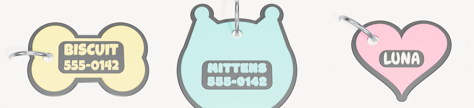 Three finished pet tags: a bone reading BISCUIT above a phone number, a cat's head reading MITTENS above a phone number, and a heart reading LUNA.