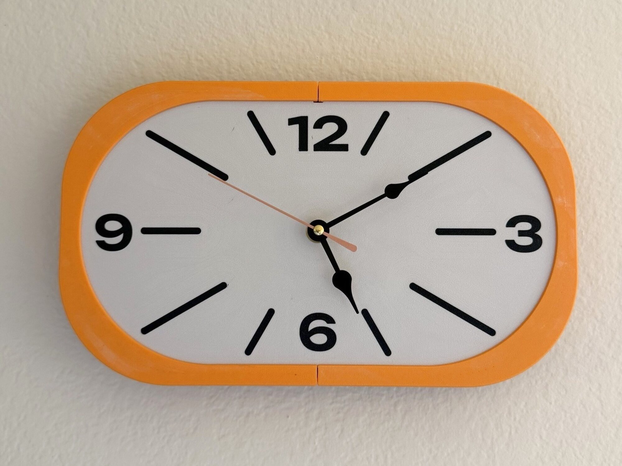 Our printed clock on a textured wall, Mandarin Orange frame and Bone White dial.